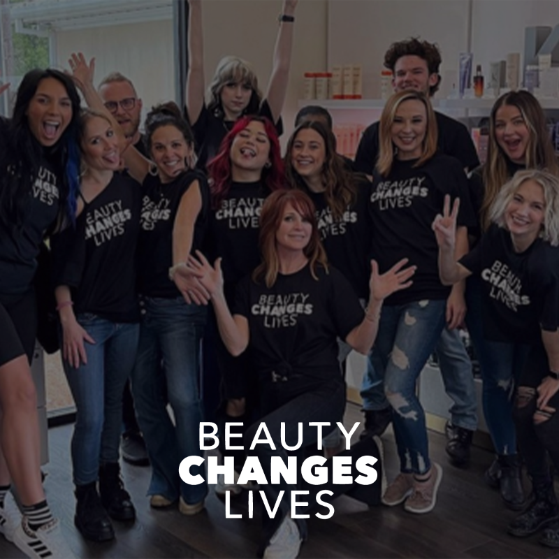 Beauty Changes Lives text over a group picture of hairstylists wearing Beauty Changes Lives T-shirts