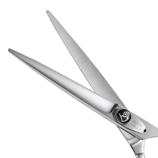 Close-up view of Sam Villa hair cutting shears with stainless steel blades and ergonomic handle, designed for precision hair cutting.