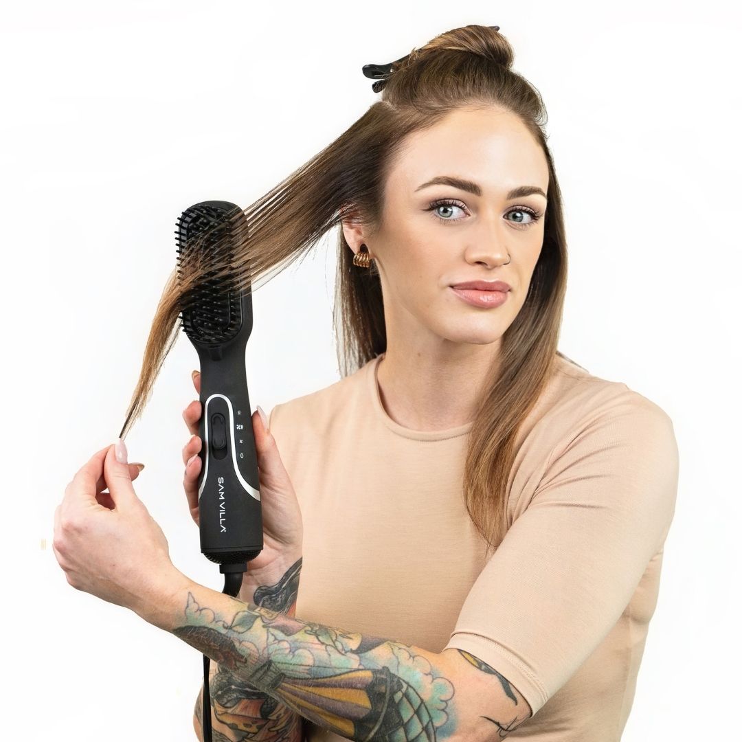 Brunette woman with tattoos using Sam Villa Pro Results 3-in-1 Blow Dry Hot Brush to style her hair.